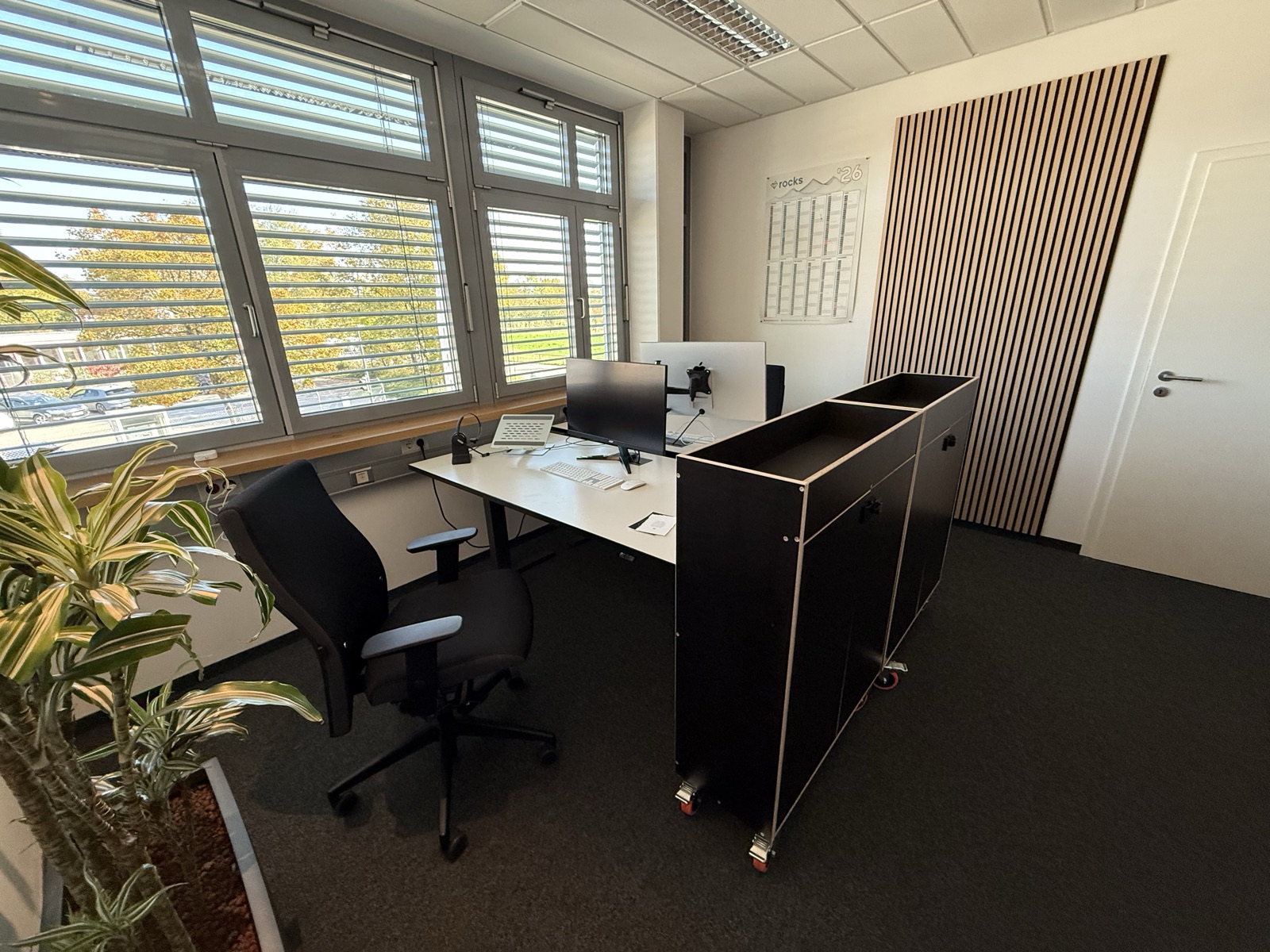 Büro A bei rocks Coworking: Schreibtische mit 27-Zoll-Monitor am Fenster, Akustikpaneel und Rollcontainer, Wasserburg am Inn